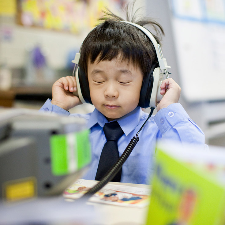 Older photo of students from Sacred Heart Catholic Primary School Westmead wearing headphones